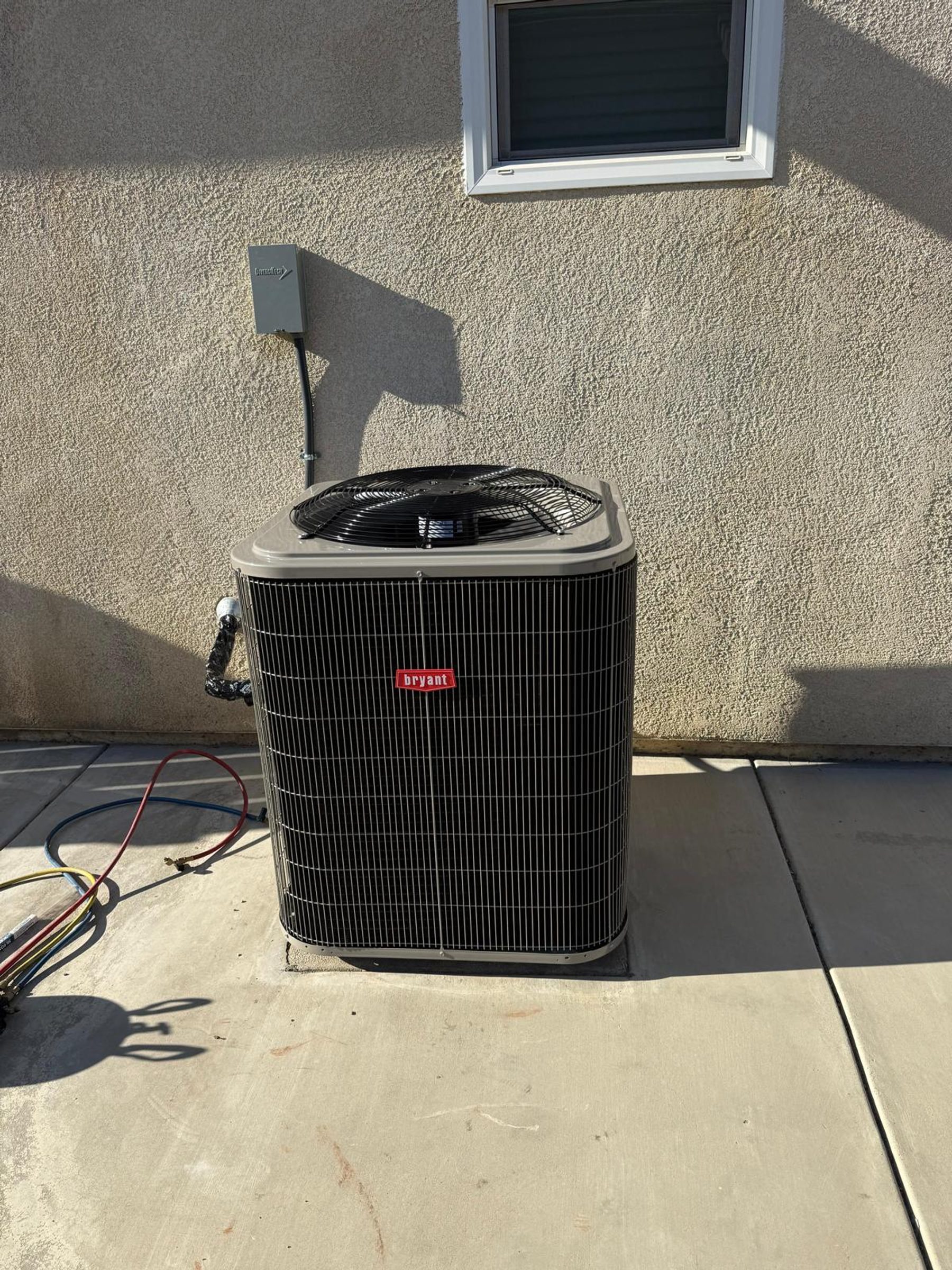 A Bryant residential condenser unit installed beside a house in the Stockton area.