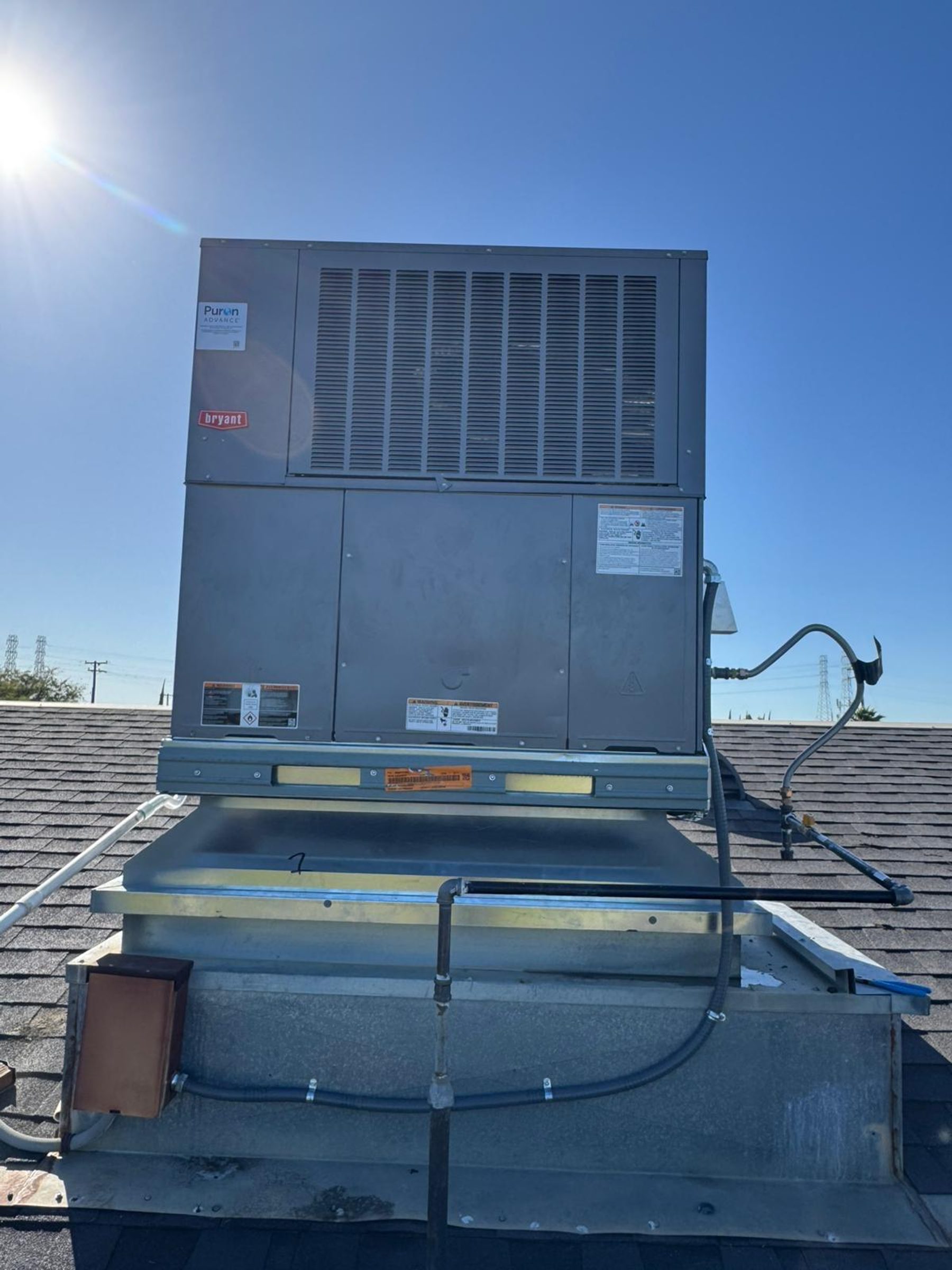 A Bryant commercial packaged unit mounted on a custom roof curb transition with weather-sealed flashing.