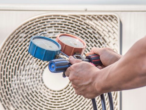 a technician spraying and cleaning an evaporator coil