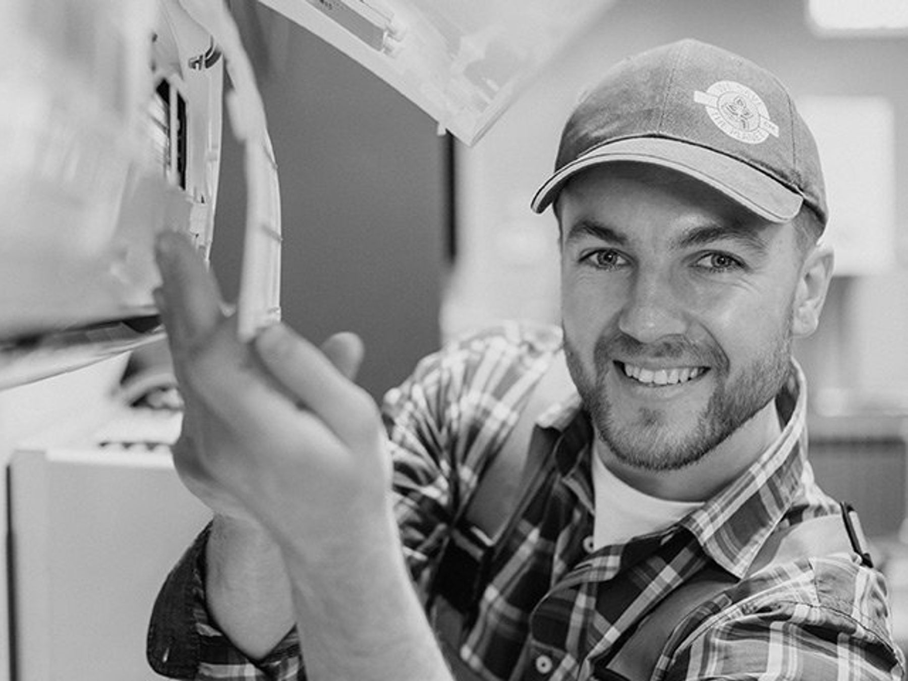 A technician sealing and checking a ductwork connection.