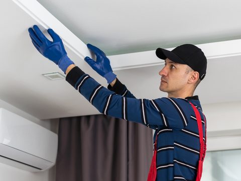A technician installing a heat pump condenser unit.