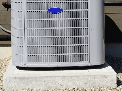 a newly installed condenser unit on a concrete pad