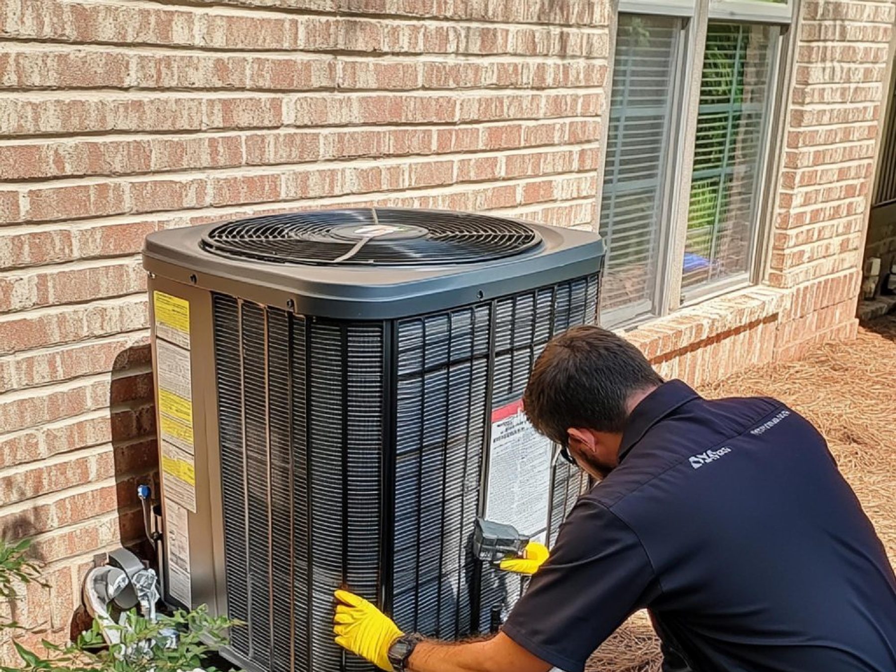 A technician replacing a residential air conditioning condenser.